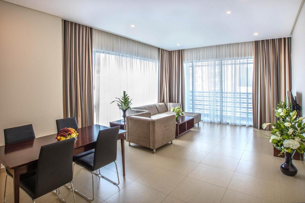 Aspire Tower في المنامة: غرفة معيشة مع أريكة وطاولة وكراسي