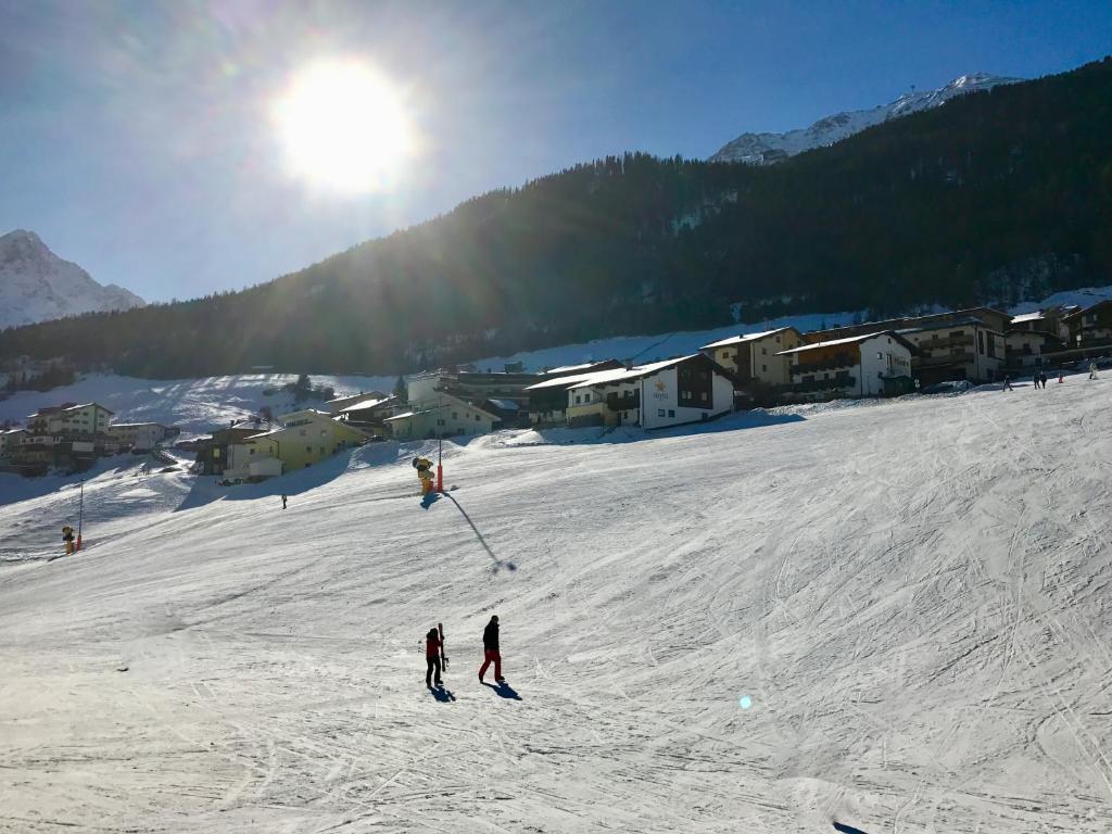 a group of people skiing down a snow covered slope at Appartement Kneisl in Sölden