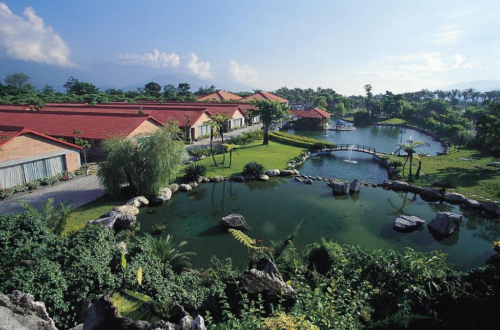 un grande laghetto con un ponte in un cortile di Yi Yuan Resort a Fengping