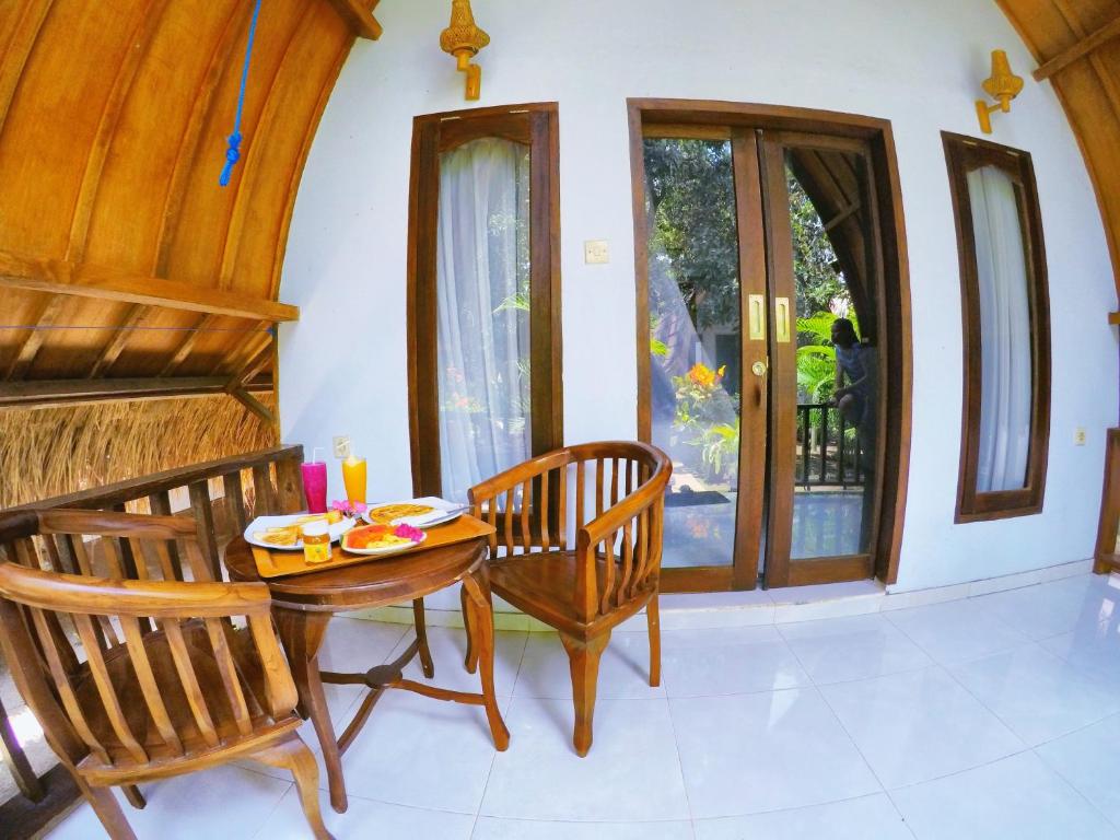 ein Esszimmer mit einem Tisch und 2 Stühlen in der Unterkunft Ina Gili Guesthouse in Gili Air