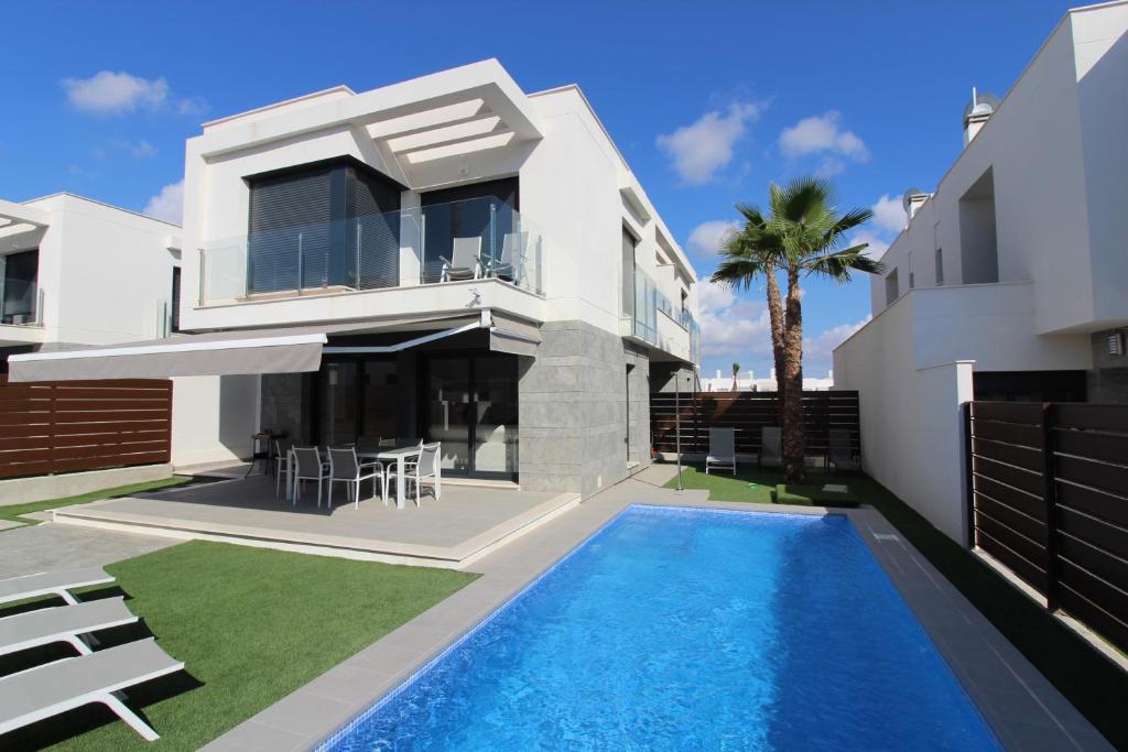 uma villa com piscina em frente a uma casa em Vistabella em Orihuela
