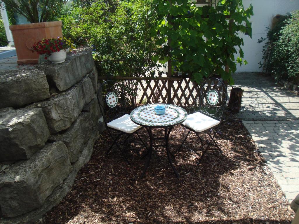 a table and two chairs sitting next to a stone wall at Elisa in Solothurn