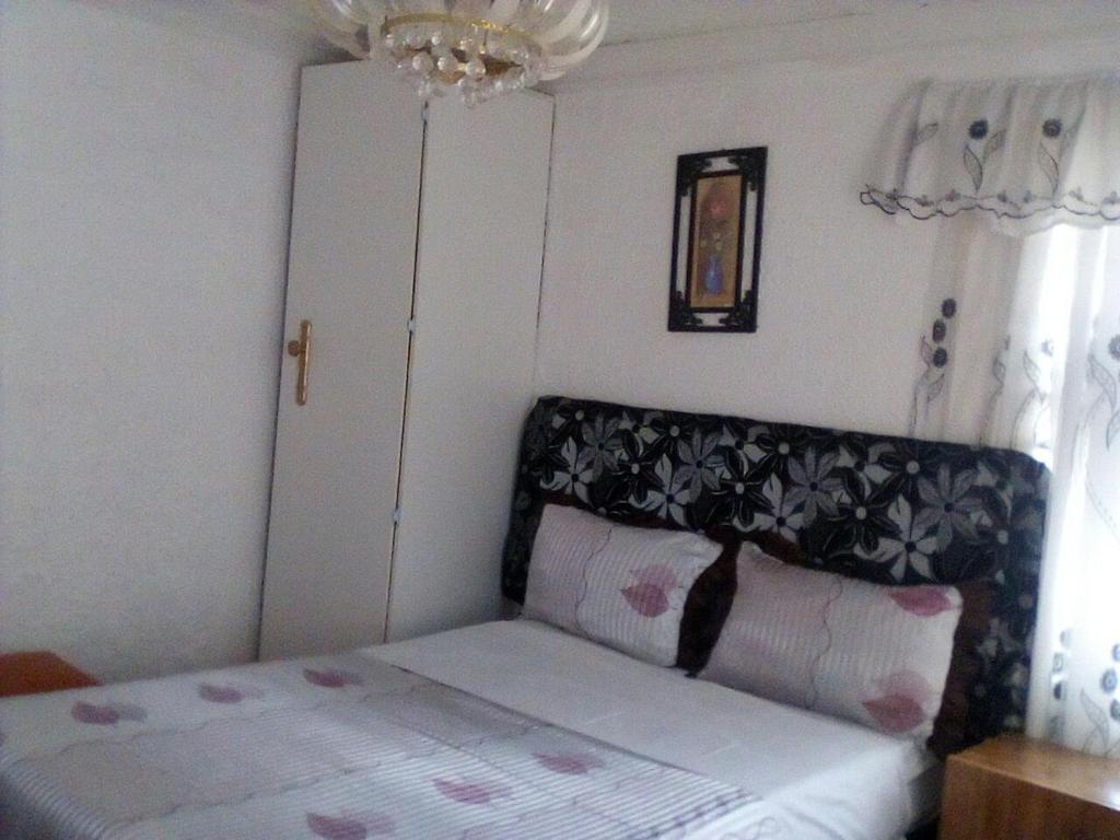 sypialnia z łóżkiem z zagłówkiem i oknem w obiekcie Guest House Macauly w mieście Johannesburg