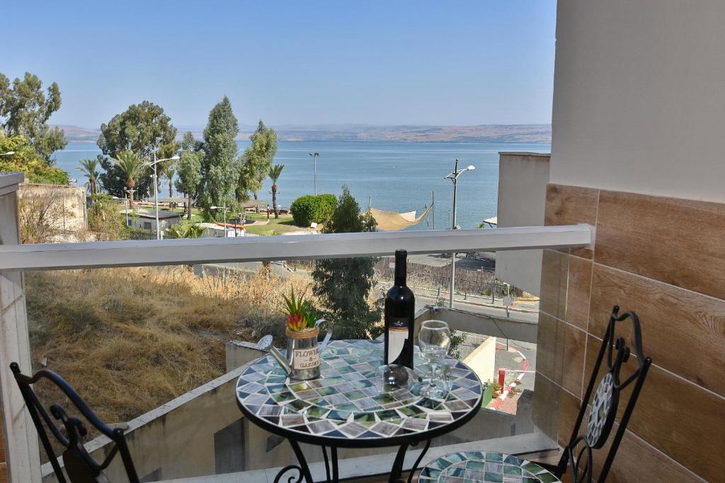 a table with a bottle of wine on a balcony at Boutique Lake Kinneret Apartment in Tiberias
