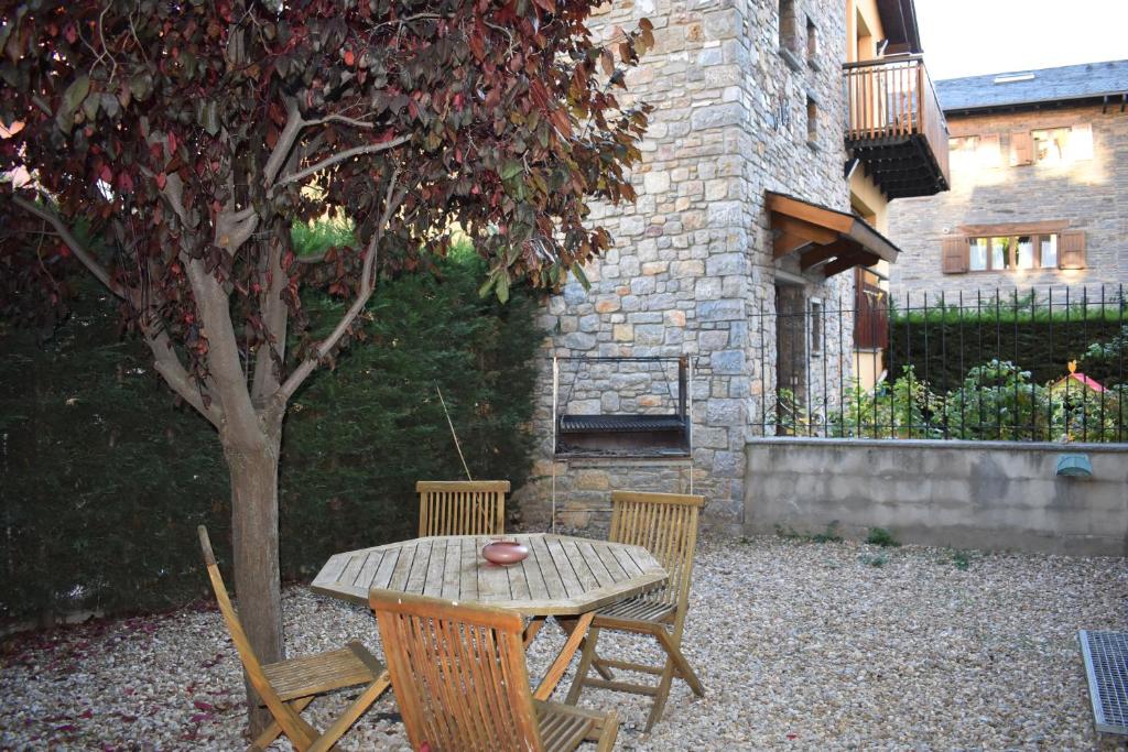 einen Holztisch und Stühle neben einem Baum in der Unterkunft Casa Puigcerda in Puigcerdà