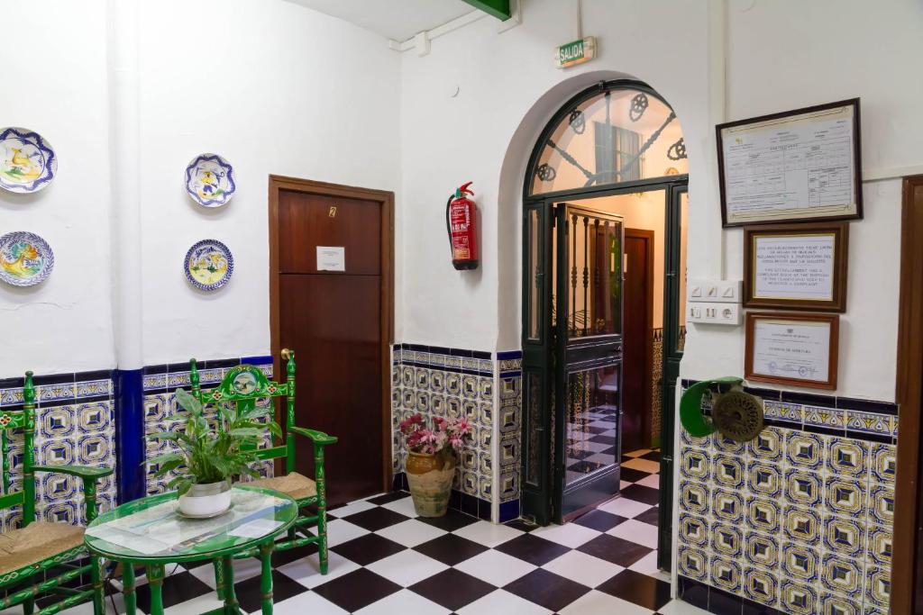 a room with a door and a checkered floor at Pensión San Benito Abad in Seville