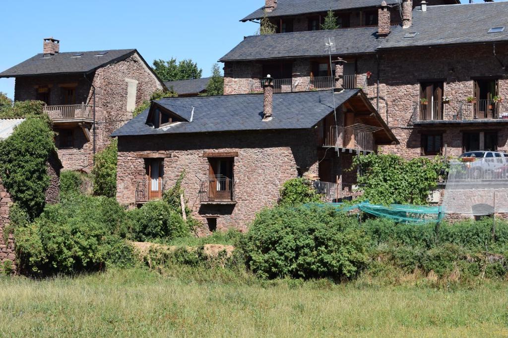 an old stone house with a black roof at Ca L'Emili in Llagunes