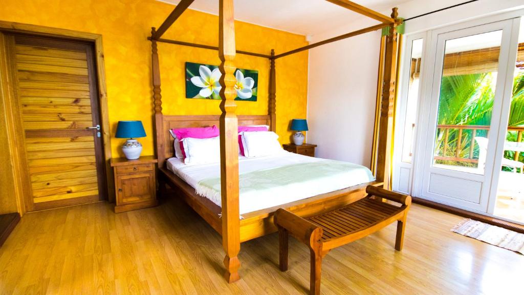 a bedroom with a four poster bed and a window at Pingo Studio in Le Morne