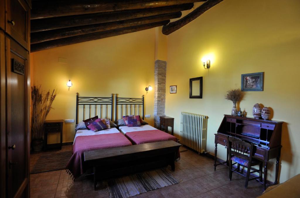 1 dormitorio con cama y piano en Casa Rural Boletas en Loporzano