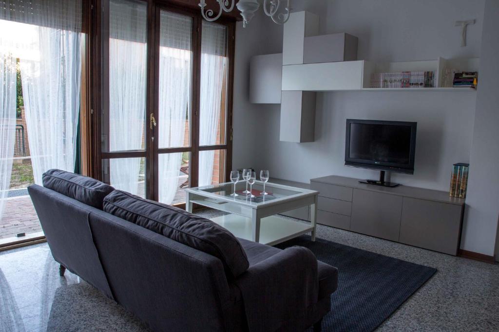 a living room with a couch and a tv and a table at Il covo di Gio' apartament in Modena