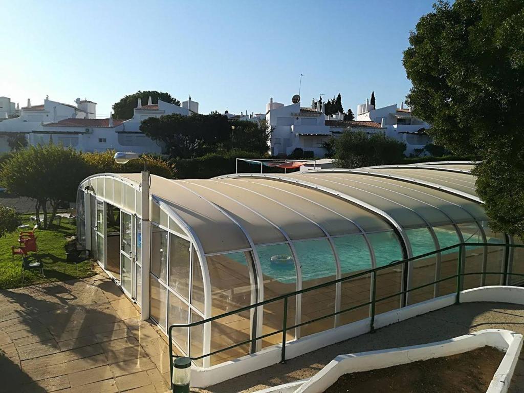 アルマカオ・デ・ペラにあるApartamento Senhora da Rochaのガラス張りの建物(スイミングプール付)
