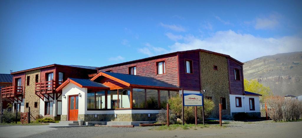 un gran edificio con un cartel delante en Hosteria Puerto San Julian en El Calafate