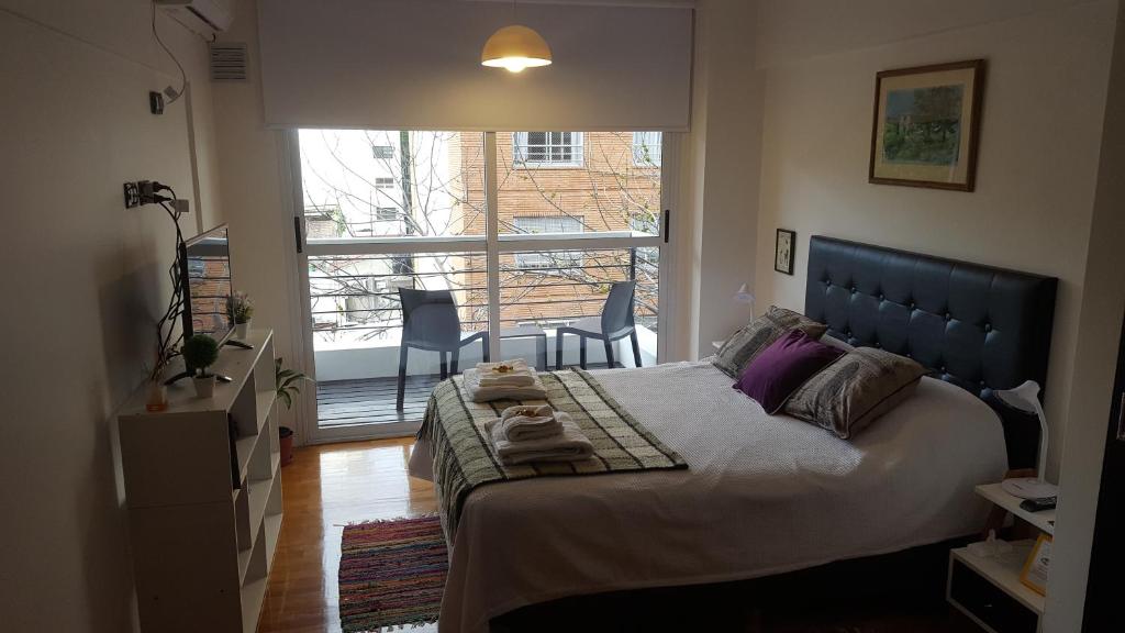 a bedroom with a large bed and a large window at Tango Cozy Estudio Luminoso WiFi in Buenos Aires