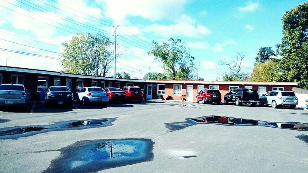 a parking lot with cars parked in front of a building at Leisure Motel in Windsor