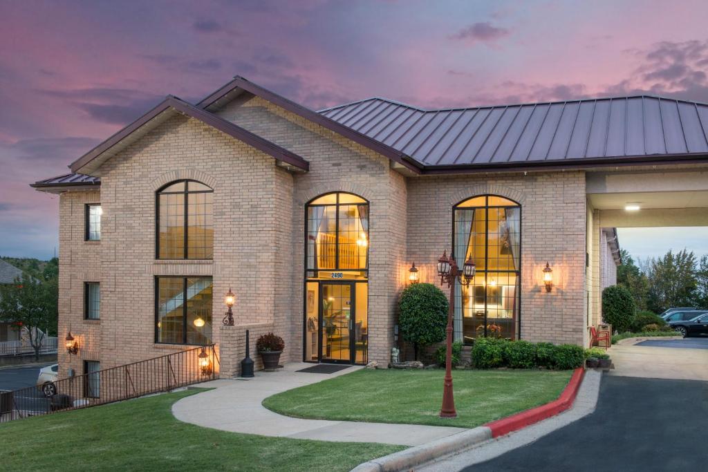 a large brick house with a dark roof at Super 8 by Wyndham Branson Thousand Hills in Branson