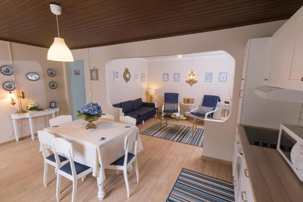 Casa da Maria في أنغرا دو إِراويزو: مطبخ وغرفة معيشة مع طاولة وكراسي