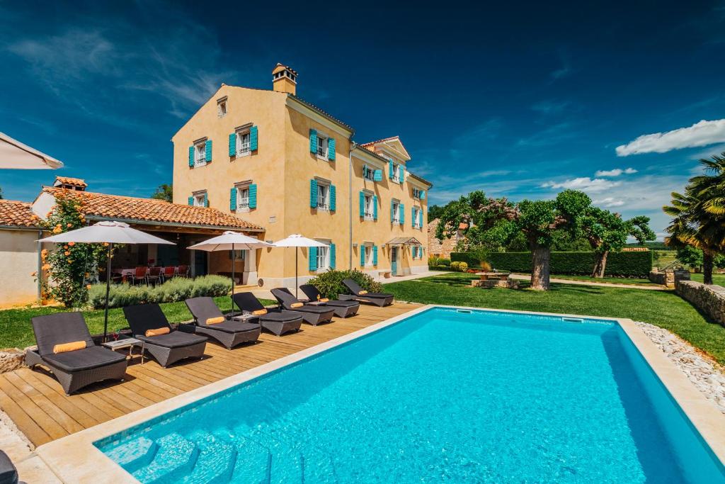 an estate with a swimming pool in front of a building at Villa Stanzia Cocci in Brtonigla