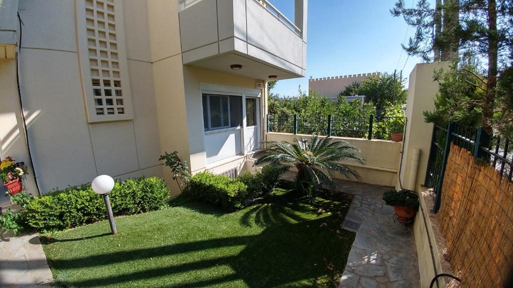 um pequeno quintal em frente a uma casa em Cozy Apartments near the airport em Artemida