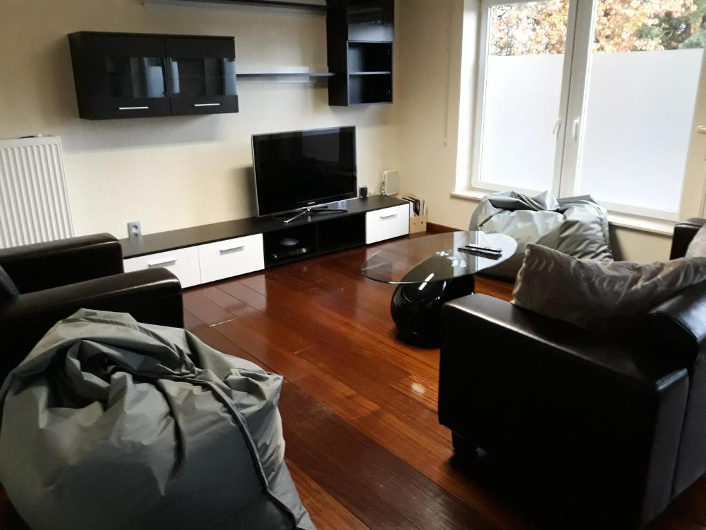 ein Wohnzimmer mit 2 Stühlen und einem Flachbild-TV in der Unterkunft Cosy Corner in Lommel