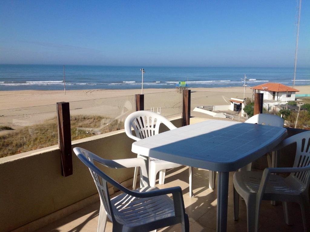 a blue table and chairs on a balcony with the beach at Namaste casas de mar in Villa Gesell