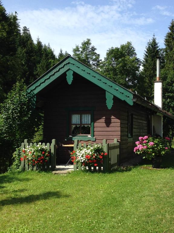 a small house with flowers in the yard at Ferienhütte in Ruhpolding in Ruhpolding