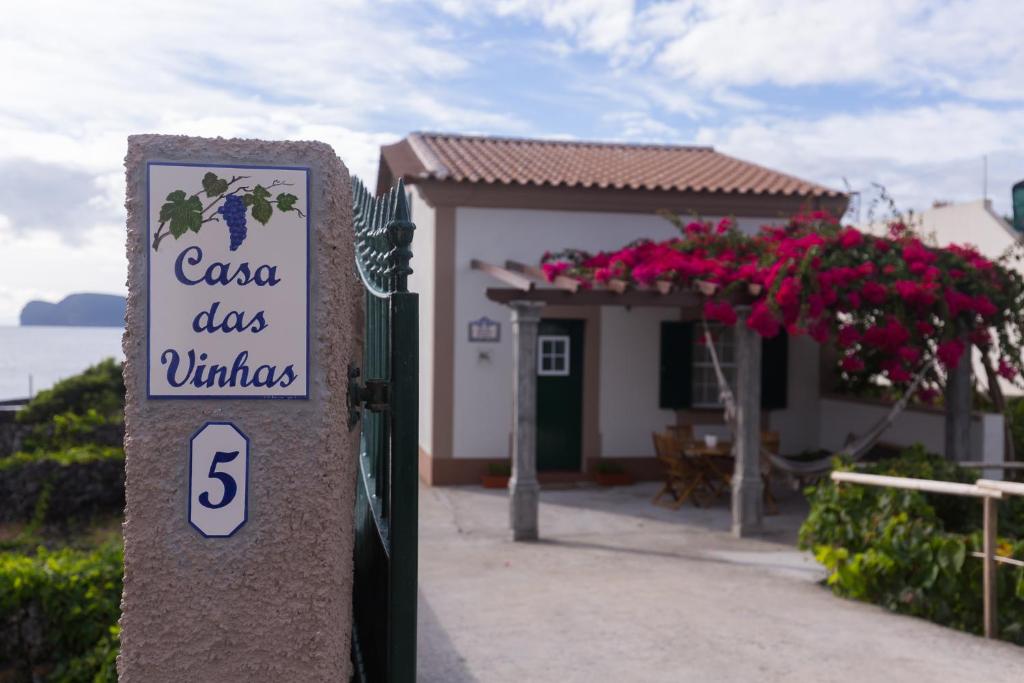 a sign for a casa dos villas with a building at Casa das Vinhas in Feteira