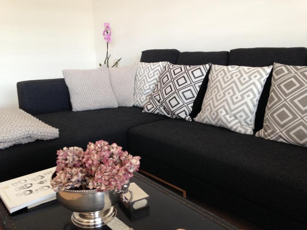 a black couch with pillows in a living room at AVLiving City INSIDE NINE Basel in Basel