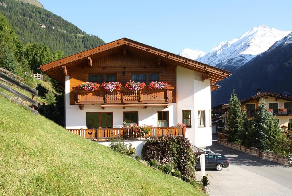 a house with a balcony with flowers on it at Appartement Ferienglück in Sölden