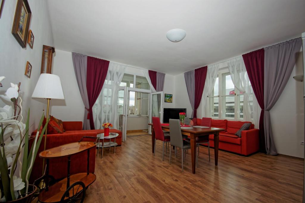 salon z czerwoną kanapą i stołem w obiekcie Spacious Prague View Apartment w Pradze