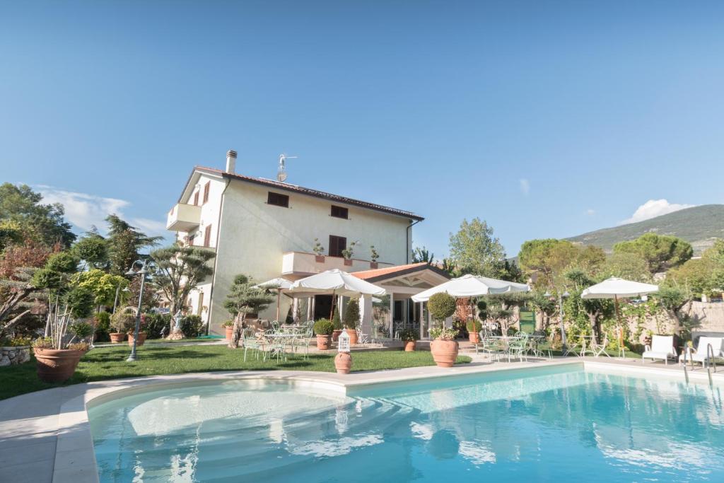 a villa with a swimming pool in front of a house at Il Giardino degli Angeli in Rivotorto 