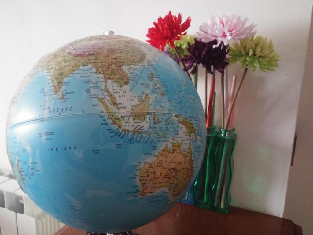 a globe on a table next to vases with flowers at Accogliente e ospitale B&B in Perugia