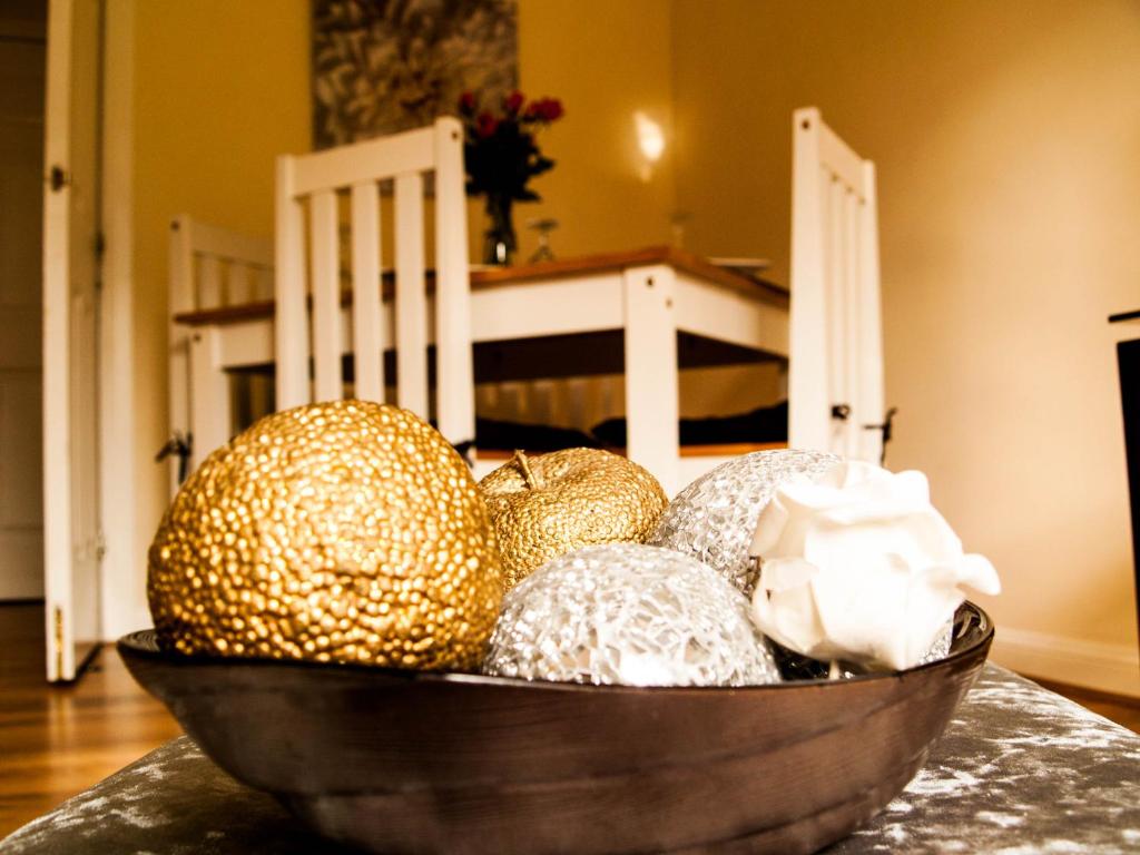 un bol de fruta sentado sobre una mesa en King Court Apartment, en Motherwell