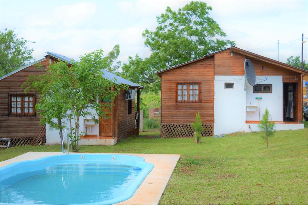 a house and a swimming pool in front of a house at Las Cabanas in Jardín América