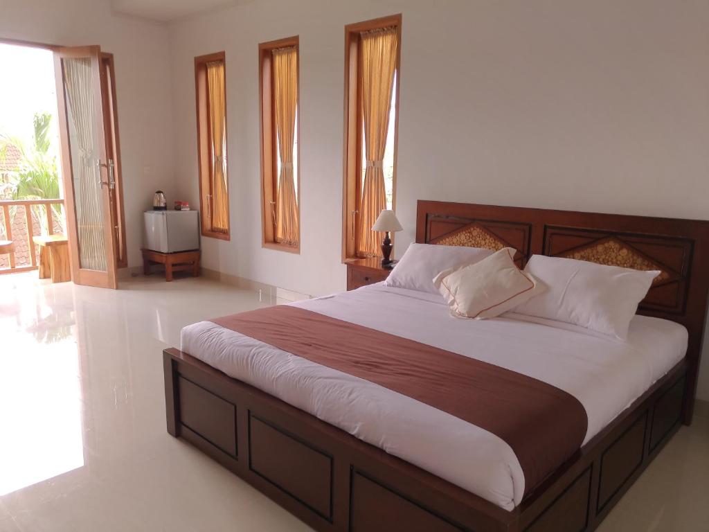 een slaapkamer met een groot bed in een kamer bij Mekenyem House Ubud in Ubud