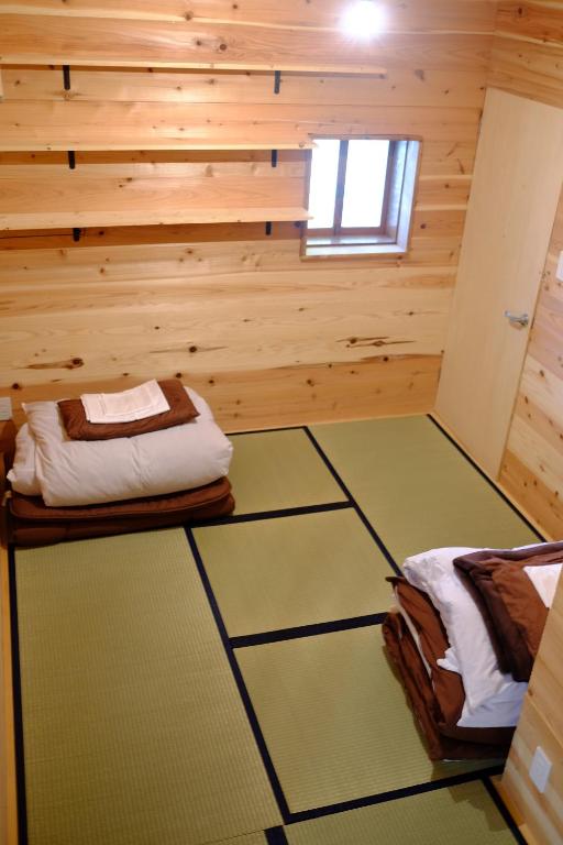 Habitación con 2 camas en una cabaña de madera en Hakone Guesthouse Toi, en Hakone