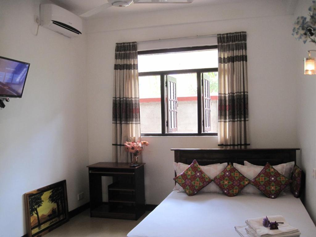 a bedroom with a bed and a window at Miheen Hotel & Resort - Anuradhapura in Mihintale