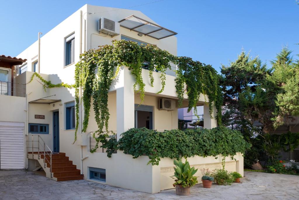 a white building with ivy on it at Villa Castellina & Emmanouela holiday apartment in Almyrida