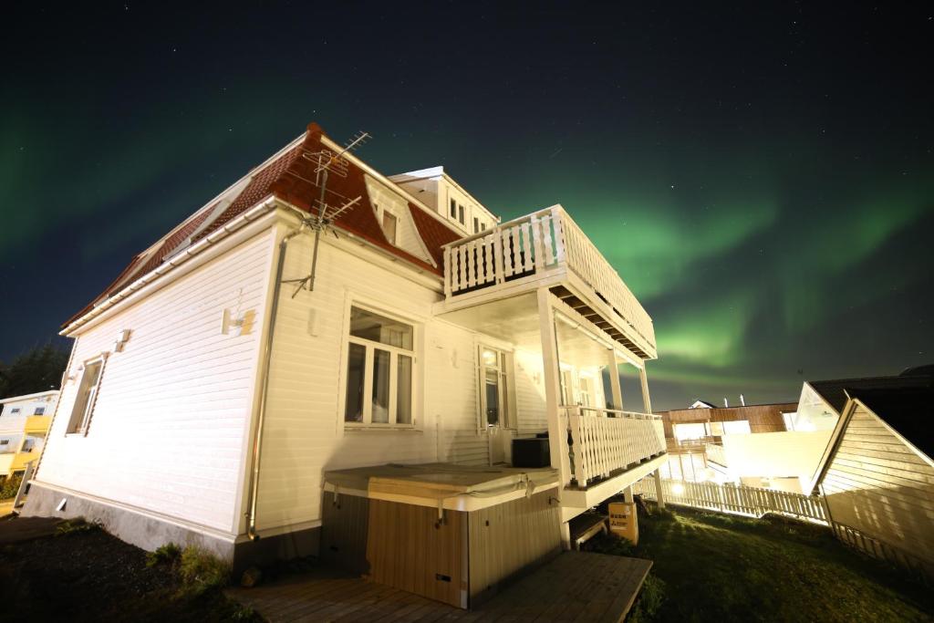 een huis met het noorderlicht in de lucht bij BraMy Apartments The Bucks Villa in Tromsø