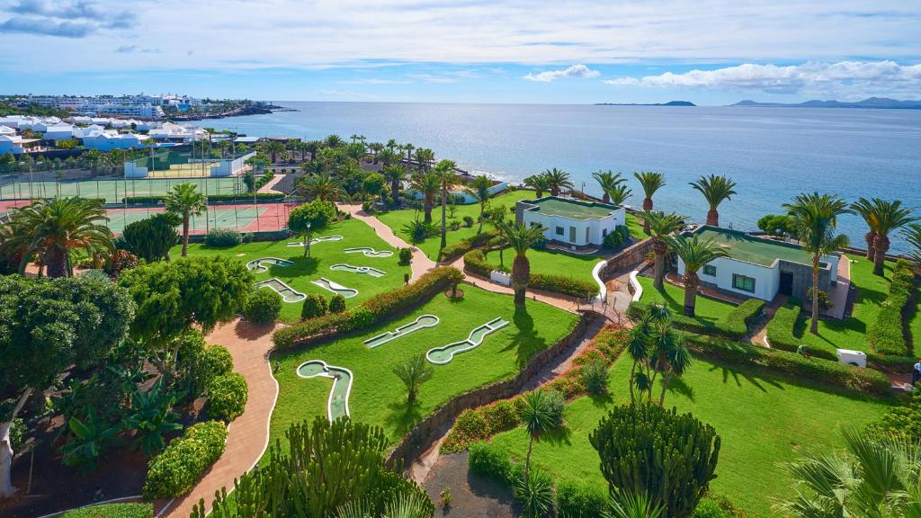 an aerial view of a park with palm trees and the ocean at Hipotels Natura Palace Adults Only in Playa Blanca