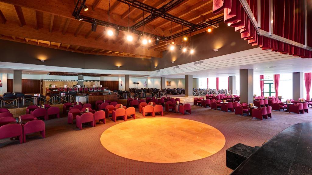 a large room with red chairs and a large table at Hipotels Natura Palace Adults Only in Playa Blanca