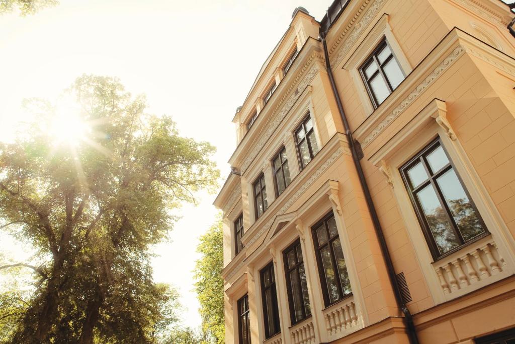 un edificio con un árbol delante de él en Hotel Villa Anna, en Uppsala