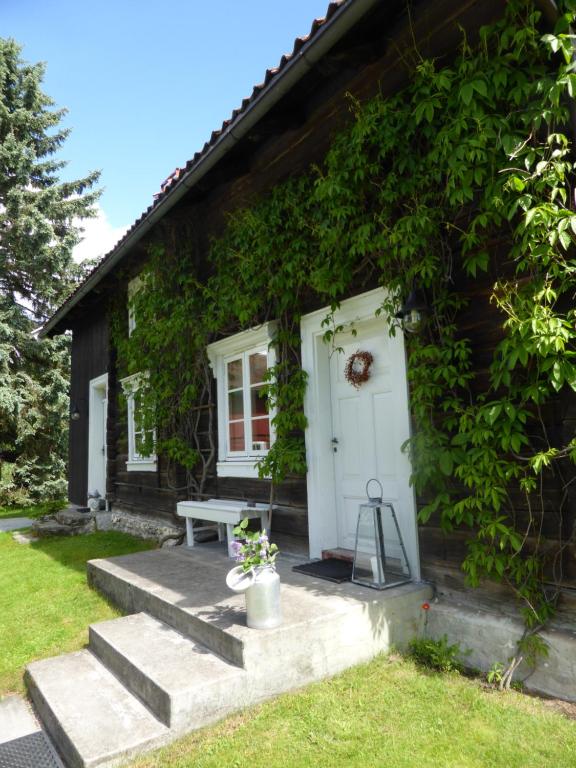 a small house with a white door and a bench at Bjørke Østre in Løten