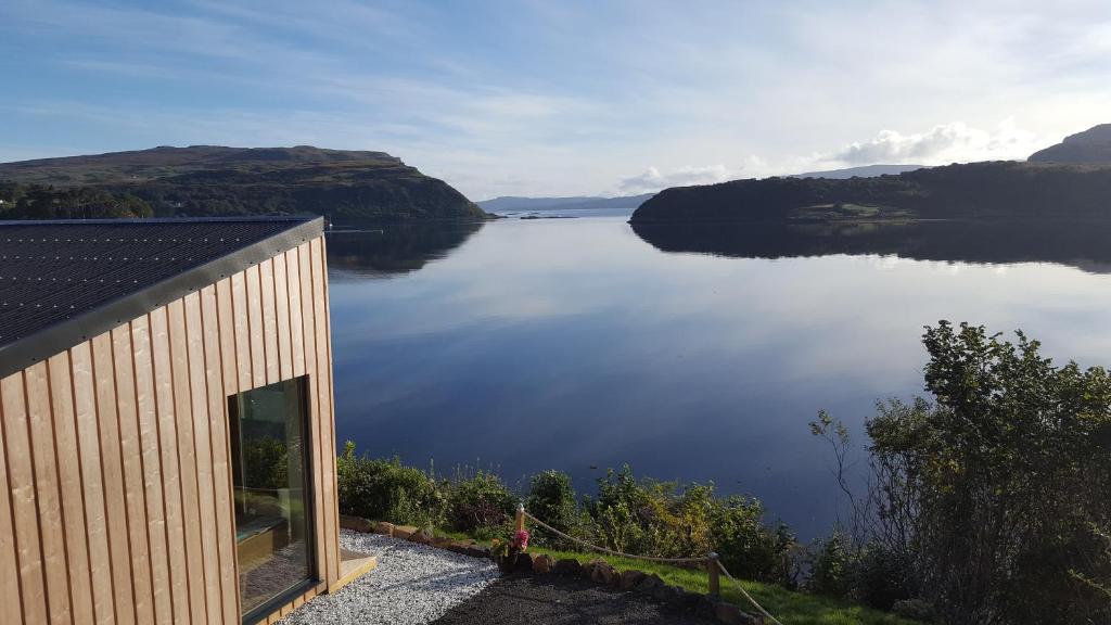 a building with a view of a large body of water at Air an Oir - Skye Self Catering in Portree