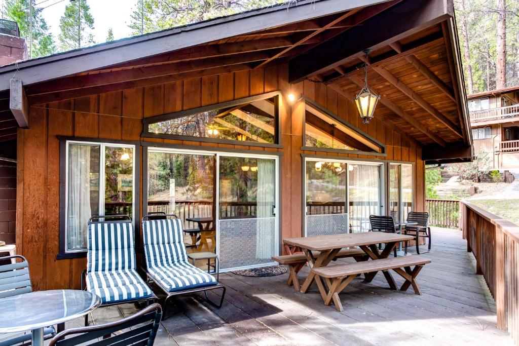 un patio con mesa, sillas y ventanas en 12B Star Gazers, en Wawona