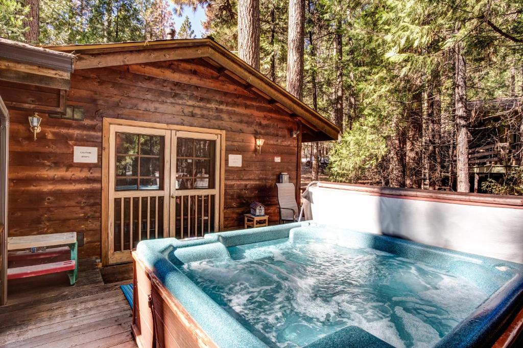 a hot tub on the deck of a log cabin at 41A Cedar Chalet in Wawona