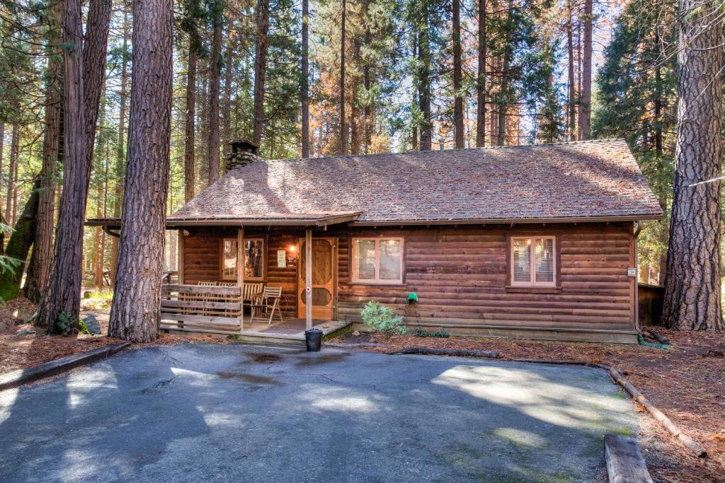 a log cabin in the middle of a forest at 53 Creekside Cabin in Wawona