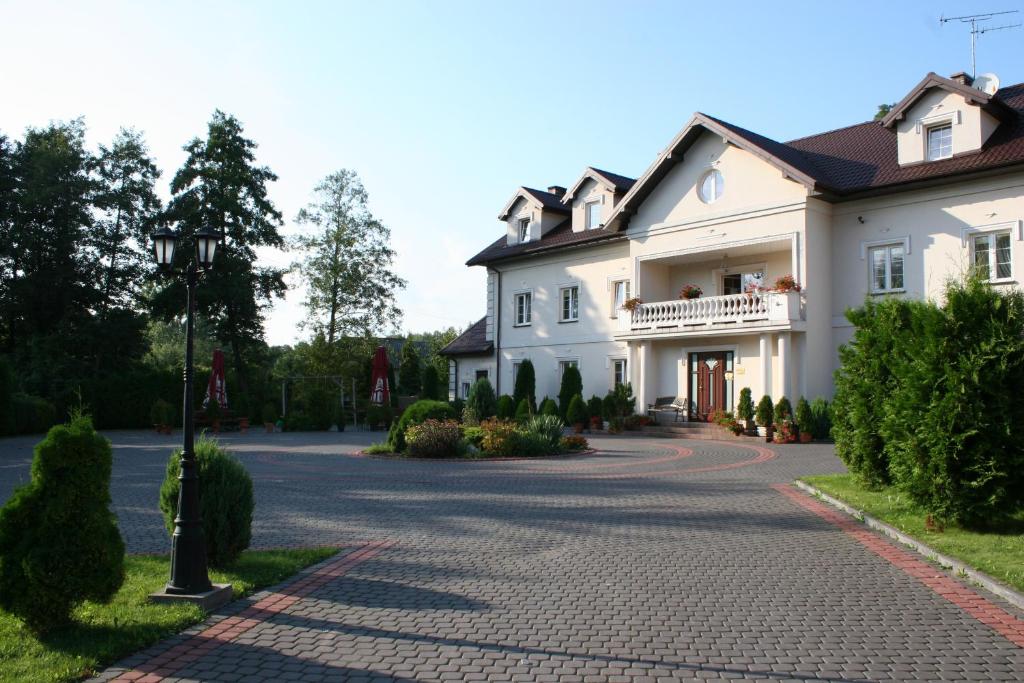 a large white house with a driveway at Gościniec Kuklówka in Kuklówka