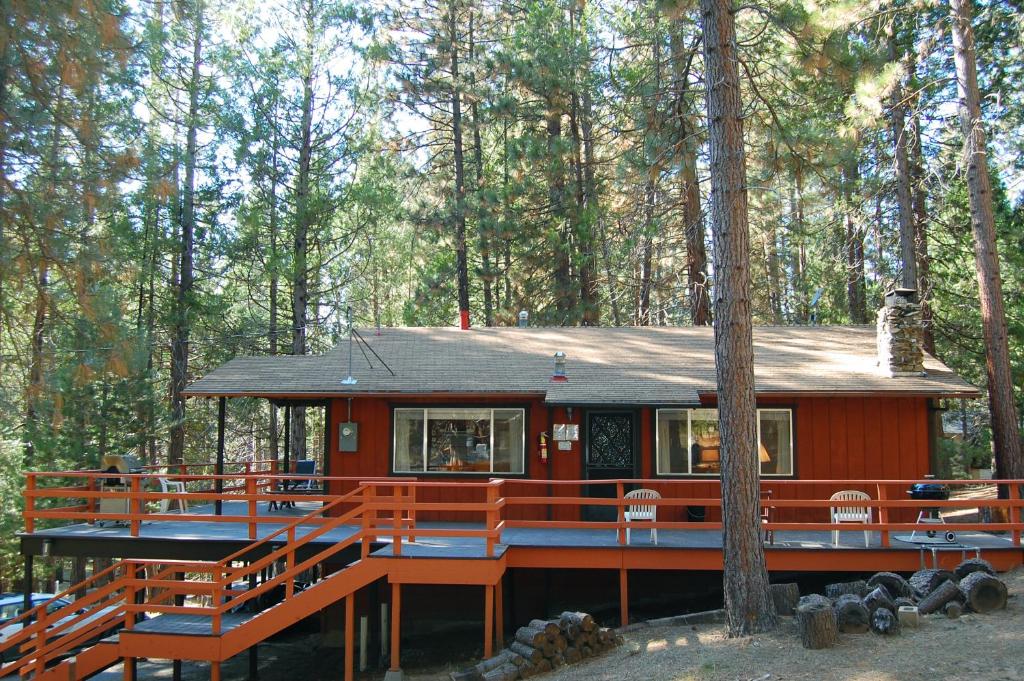 a red house with a deck in the woods at 9B Deer Hollow in Wawona