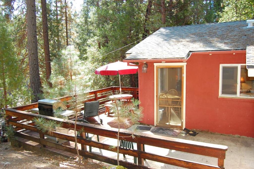 a red tiny house with a wooden deck at 65 Sparrows Nest in Wawona