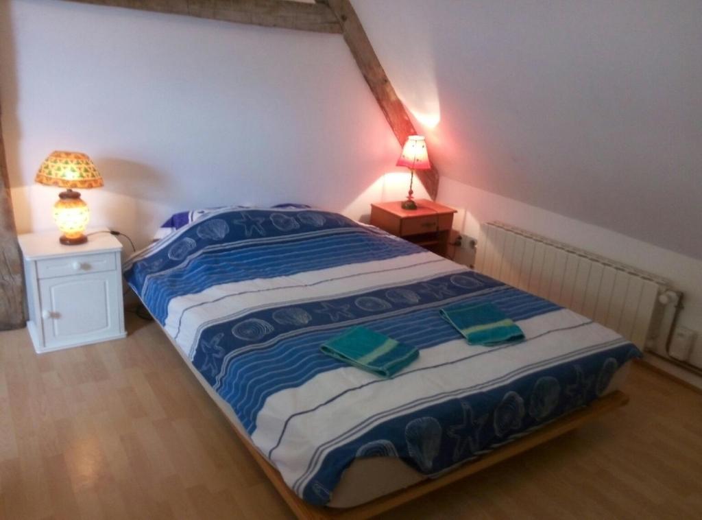 ein Schlafzimmer mit einem Bett mit zwei grünen Gläsern darauf in der Unterkunft Studio dans un cadre champetre in Moiry